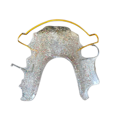 Clear retainer with gold arch bow on a white background 